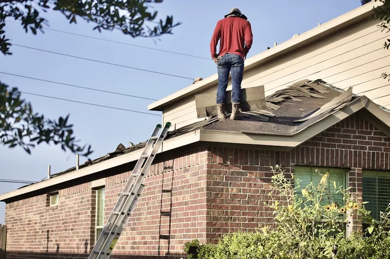 Professional roofer working on a residential roof in Sedgwick